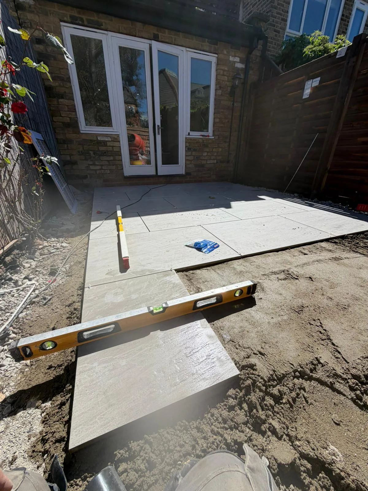 Spirit level check during porcelain patio installation Battersea