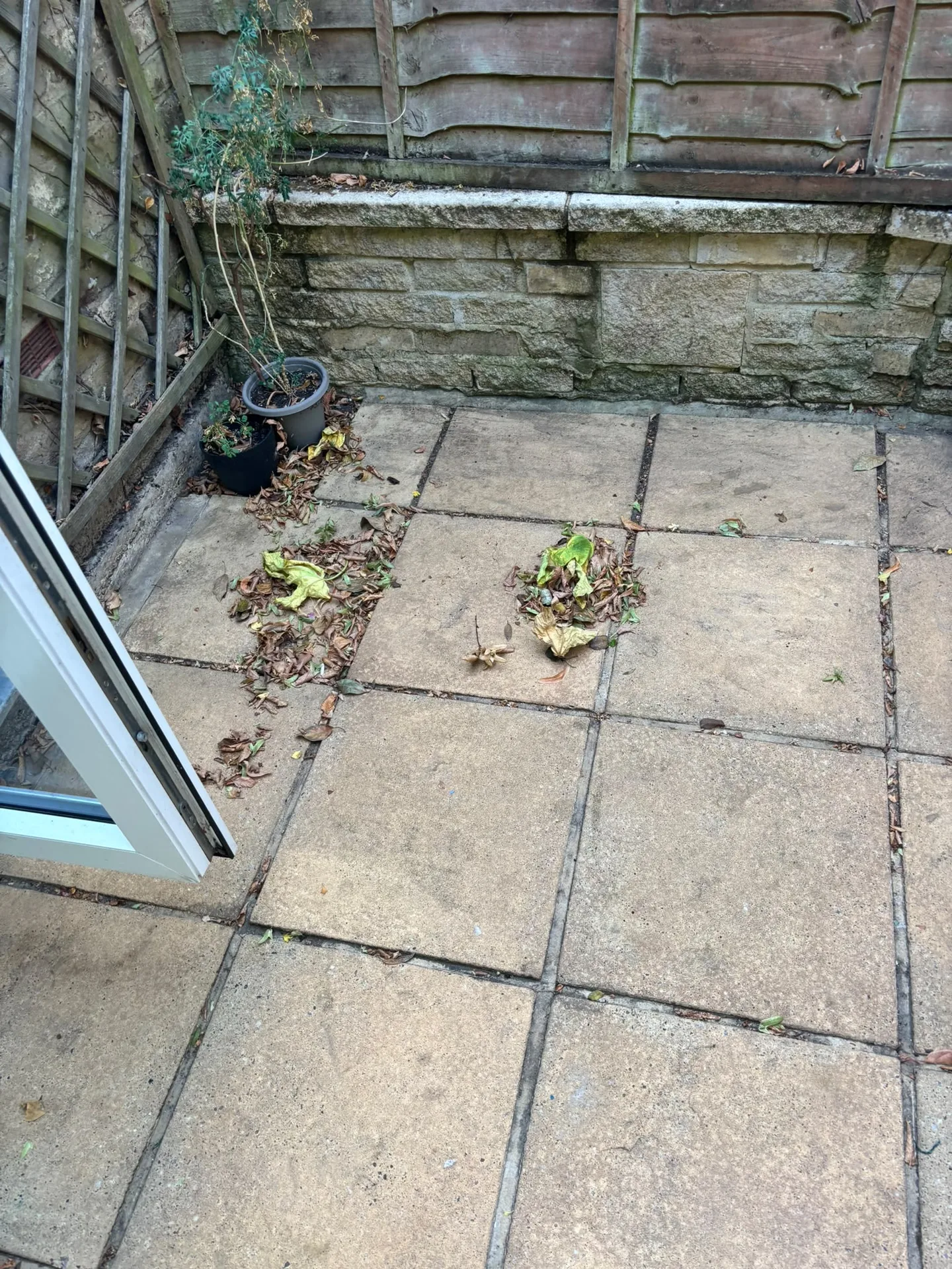 Cleaned patio slabs in a shaded garden corner after Karcher K4 pressure washing in Woodford IG8 9JN