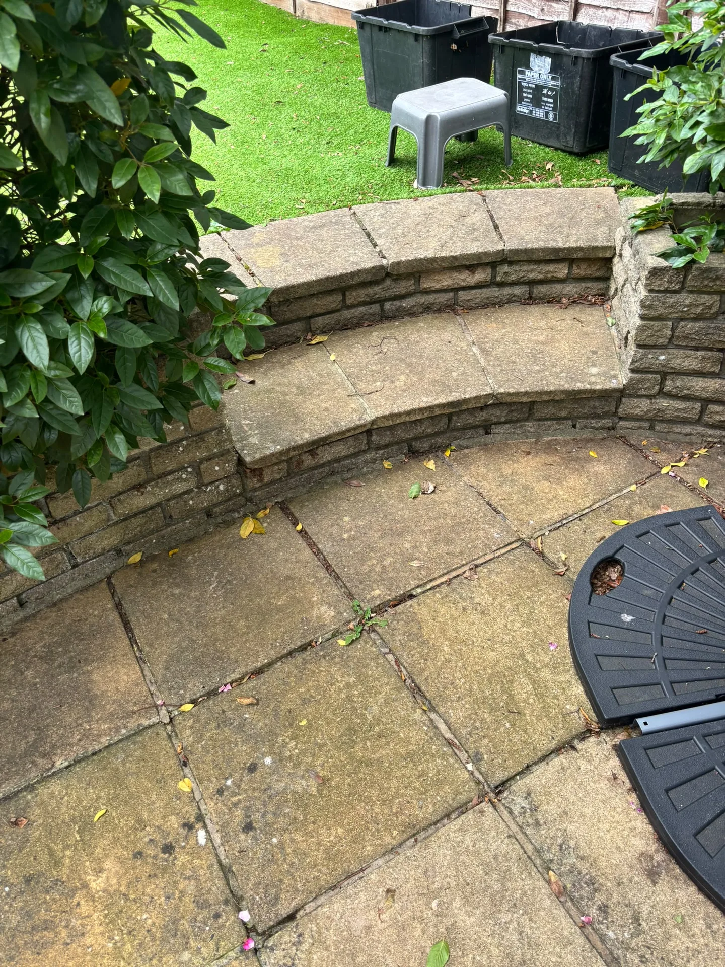 Algae-stained curved stone patio bench before Karcher K4 pressure washing in Woodford, IG8 9JN