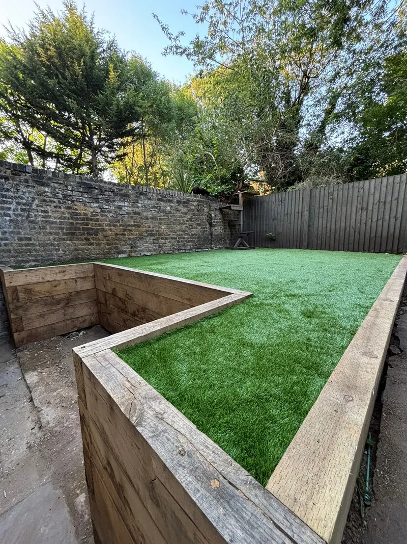 Artificial turf installation with raised timber sleeper beds