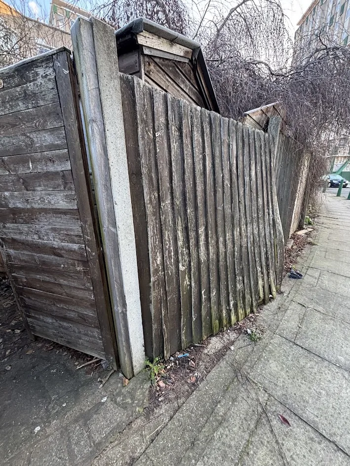 Leaning, rotten boundary fence before replacement